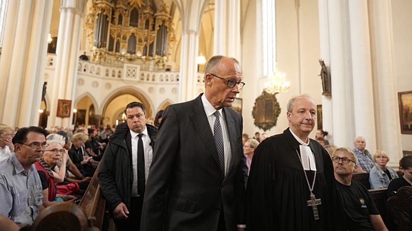 Merz meets Protestant bishop Christian Staeblein for a vigil at St Mary's Church in Berlin on 26 July 2026