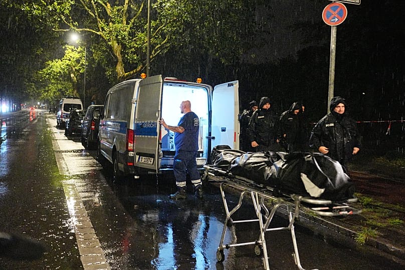 A forensic investigator carries a body believed to be of the suspect of the Berlin Pride attack in a Berlin suburb, early Monday, July 27, 2026.