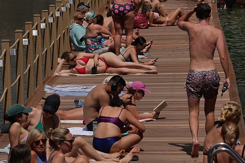 People sit at a lido in London, as a heatwave is forecast to develop in the coming days, Friday, June 19, 2026. (AP Photo/Kin Cheung)