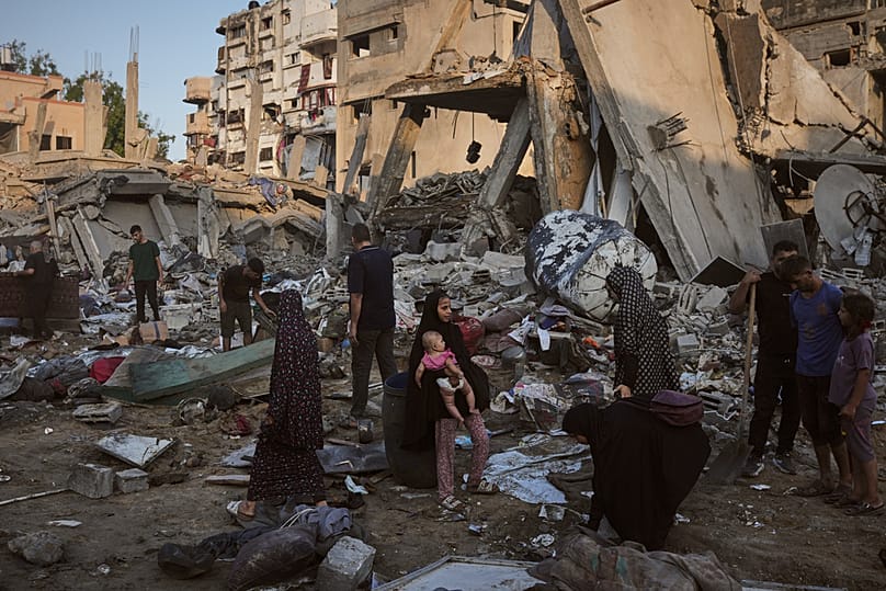 Palestinians salvage their belongings from the rubble of a building and tents destroyed in an Israeli airstrike in Gaza City, Thursday, July 30, 2026