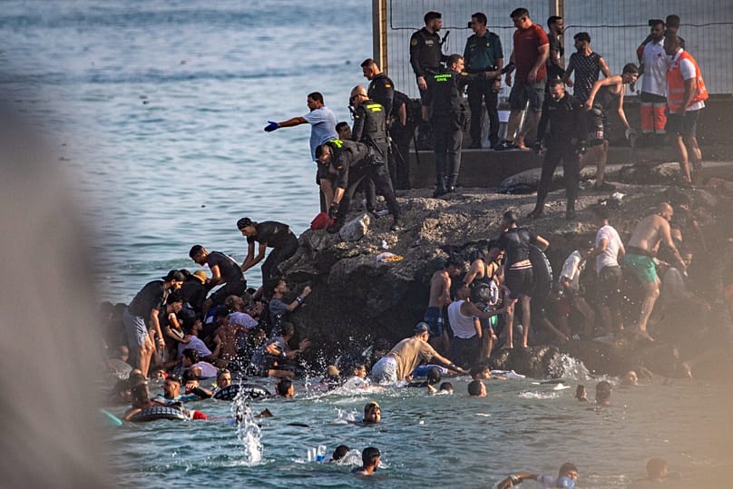 Migrants try to cross from Morocco into the Spanish enclave of Ceuta, Thursday, July 30, 2026.