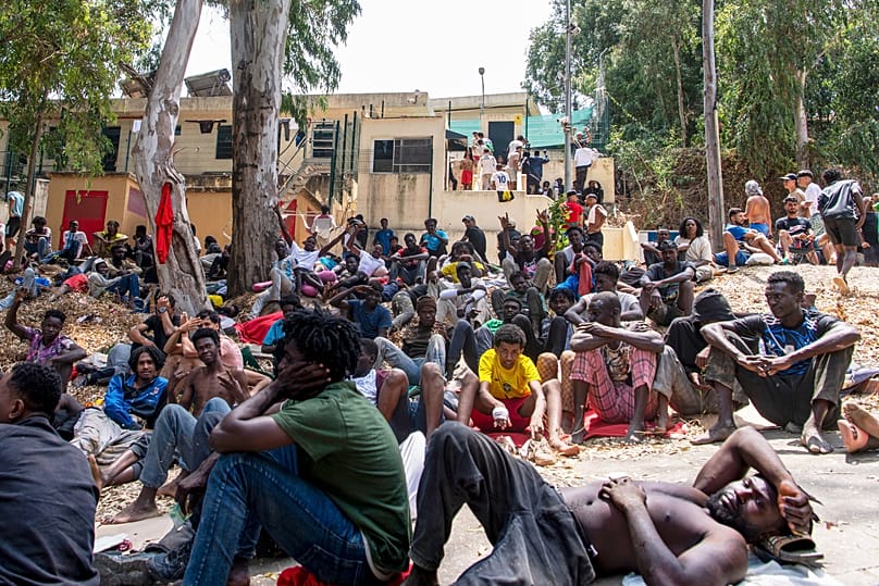 Migrants rest outside the Temporary Immigrant Centre (CETI) after crossing from Morocco into the Spanish enclave of Ceuta on 31 July 2026.