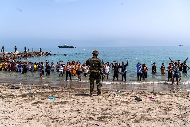 Spanish army soldiers block access to the beach for people crossing from Morocco into the Spanish enclave of Ceuta, Friday, July 31, 2026.