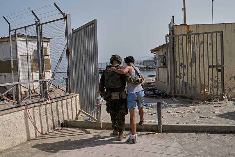 An injured migrant who crossed into Spain returns to Morocco with the assistance of a Spanish soldier from the Spanish enclave of Ceuta, Saturday, Aug. 1, 2026.