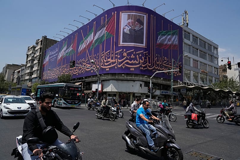 Vehicles drive past a billboard showing a the late Iranian Supreme Leader Ayatollah Ali Khamenei in downtown Tehran, 1 August, 2026