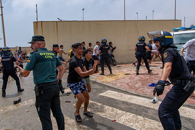 Spanish police officers intervene as migrants cross from Morocco into the Spanish enclave of Ceuta, Thursday 30 July 2026.