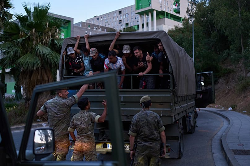 Migrants who crossed into Spain are escorted by Spanish soldiers towards the Spanish-Moroccan border for their return to Morocco on 2 August 2026.