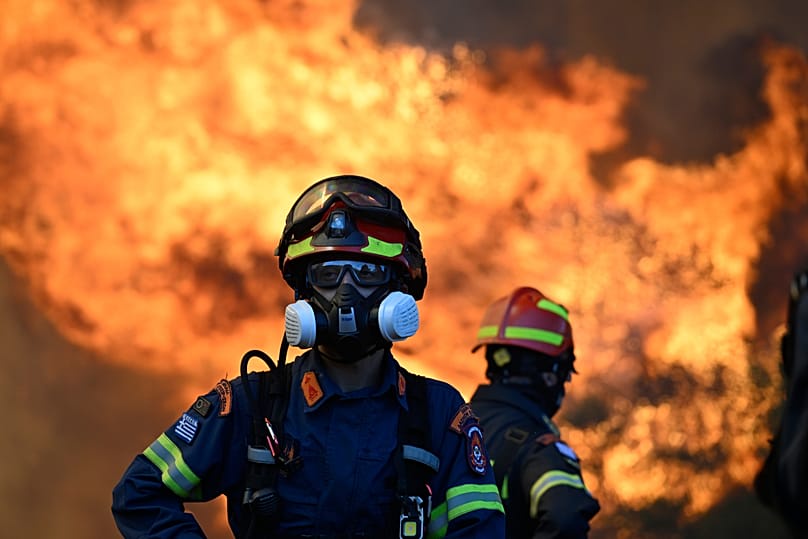 A firefighter stands as flames rising during a wildfire near Porto Germeno, 2 August, 2026