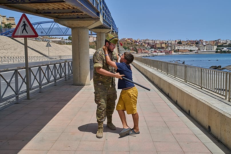 A unaccompanied minor who crossed into Spain is escorted by a Spanish soldier to the Spain-Morocco border as the child begs not to be sent back to Morocco.