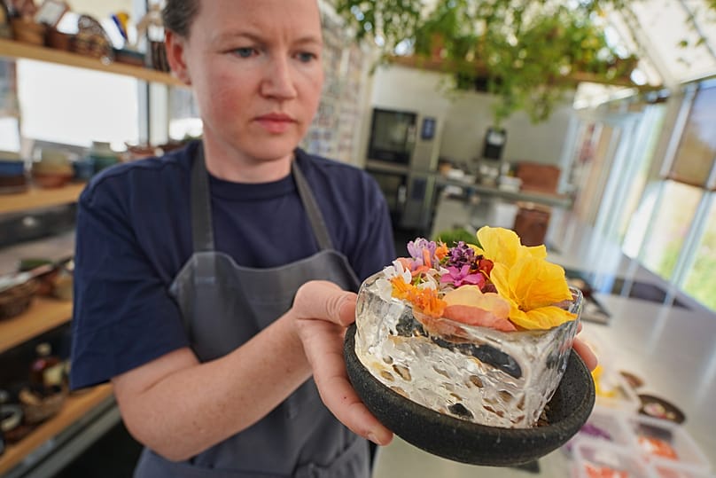 Noma's head of R&D Mette Brink Soberg holds a new berry gazpacho dish topped with flower petals in fine-dining restaurant Noma's test kitchen in Copenhagen, Denmark.
