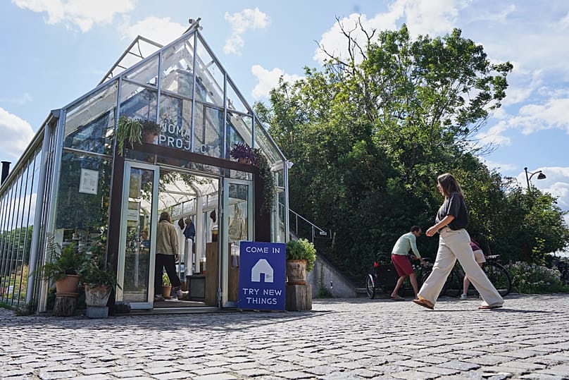 A woman enters fine-dining restaurant Noma's cafe and shop in Copenhagen, Denmark Tuesday, July 28, 2026. (AP Photo/James Brooks)