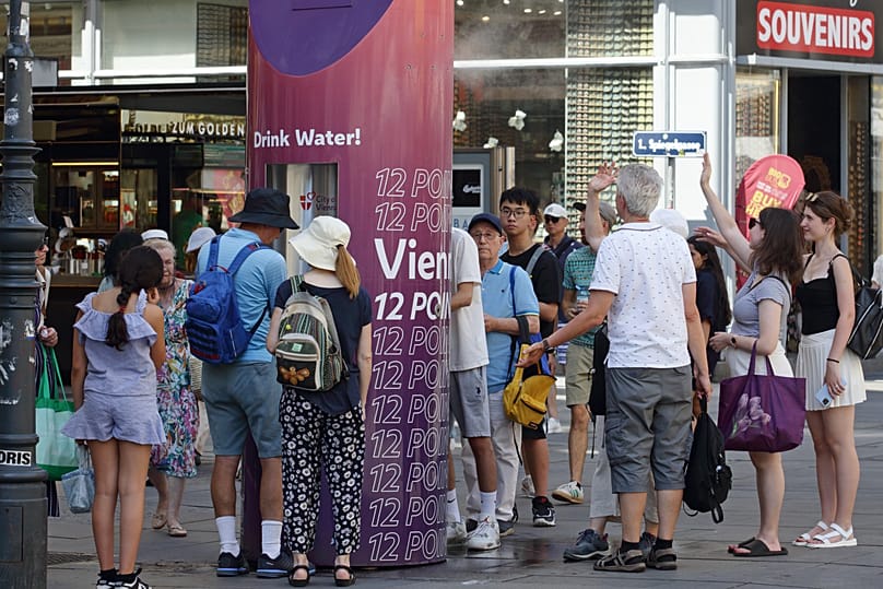 People line up to refill their water bottles on a hot summer day in Vienna, 27 June, 2026
