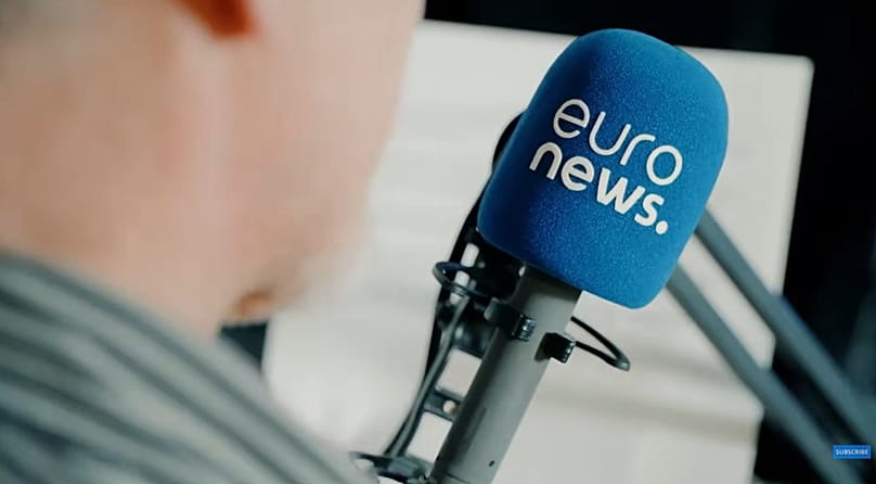 A presenter speaks into a Euronews microphone