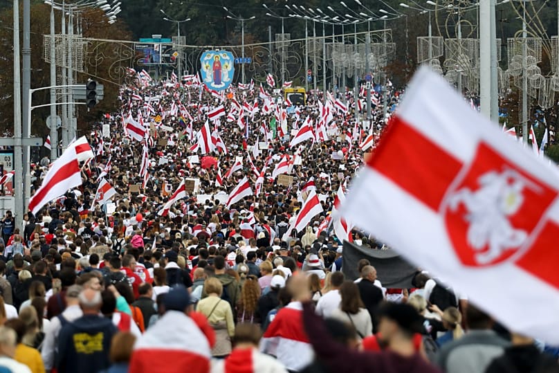 FILE: FILE - Protesters with old Belarusian national flags march at an opposition rally in Minsk, Belarus, on Sept. 6, 2020.