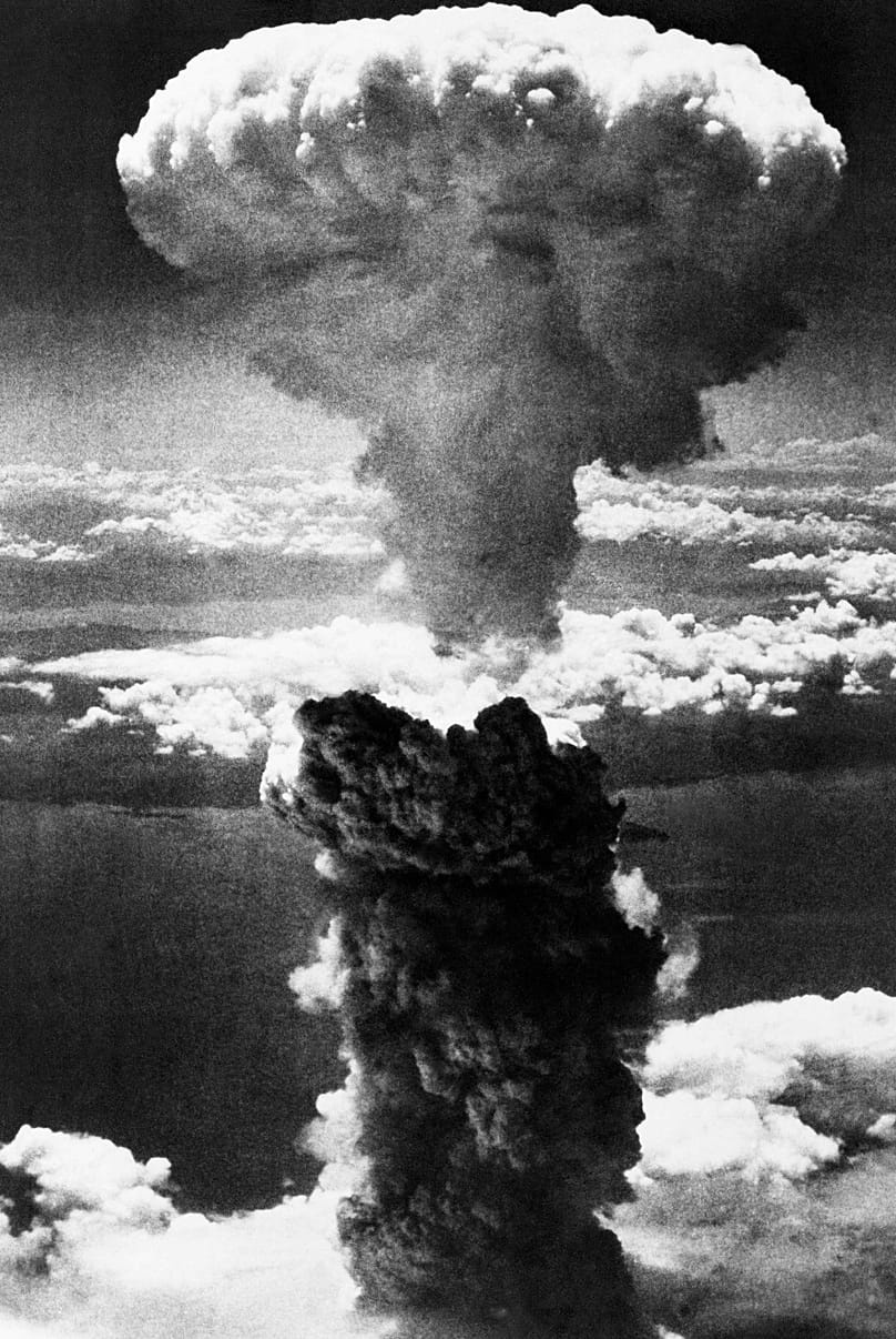 A giant column of smoke rises after the second atomic bomb ever used in warfare explodes over the Japanese port town of Nagasaki, Japan, 9 August 1945.
