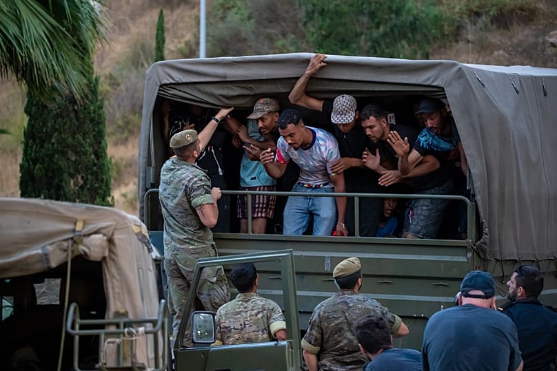 Spanish soldiers escort migrants who had crossed into Spain towards the Spanish-Moroccan border, for their return to Morocco from Ceuta, on Sunday 2 August 2026