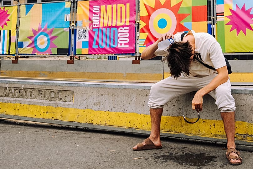 A man pours water over his head during high temperatures in the centre of Brussels, Tuesday, 4 August 2026.