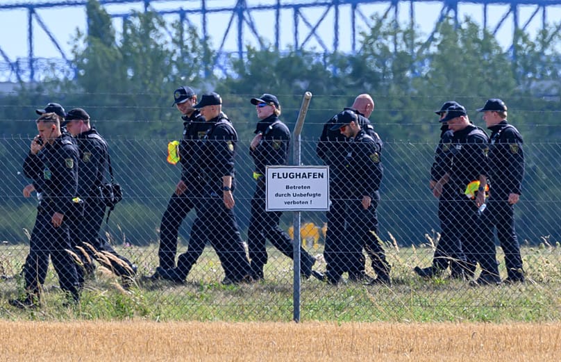Police officers search the area away from north runway on the grounds of Leipzig/Halle Airport, 6 August, 2026