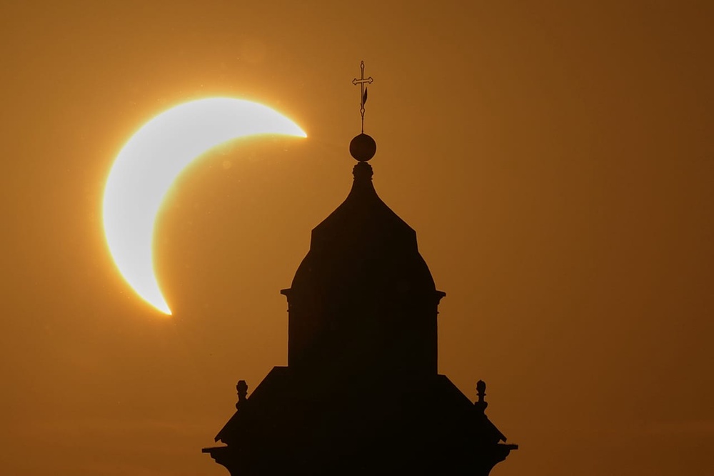 A solar eclipse is seen over a Virgin Maria church in Vidigulfo, near Pavia, northern Italy