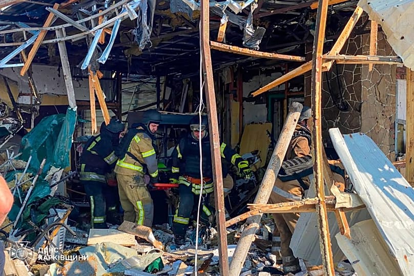 Rescuers carry a body that they removed from under the rubble of a private house following a Russian air attack in Pechenihy, 18 August, 2026