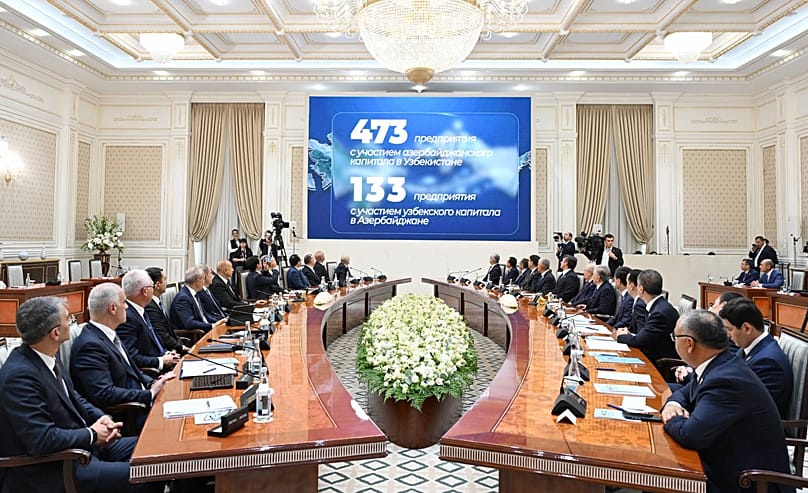 Uzbek and Azerbaijani delegations attend the Supreme Interstate Council meeting in Tashkent, as bilateral investment figures are displayed on screen.