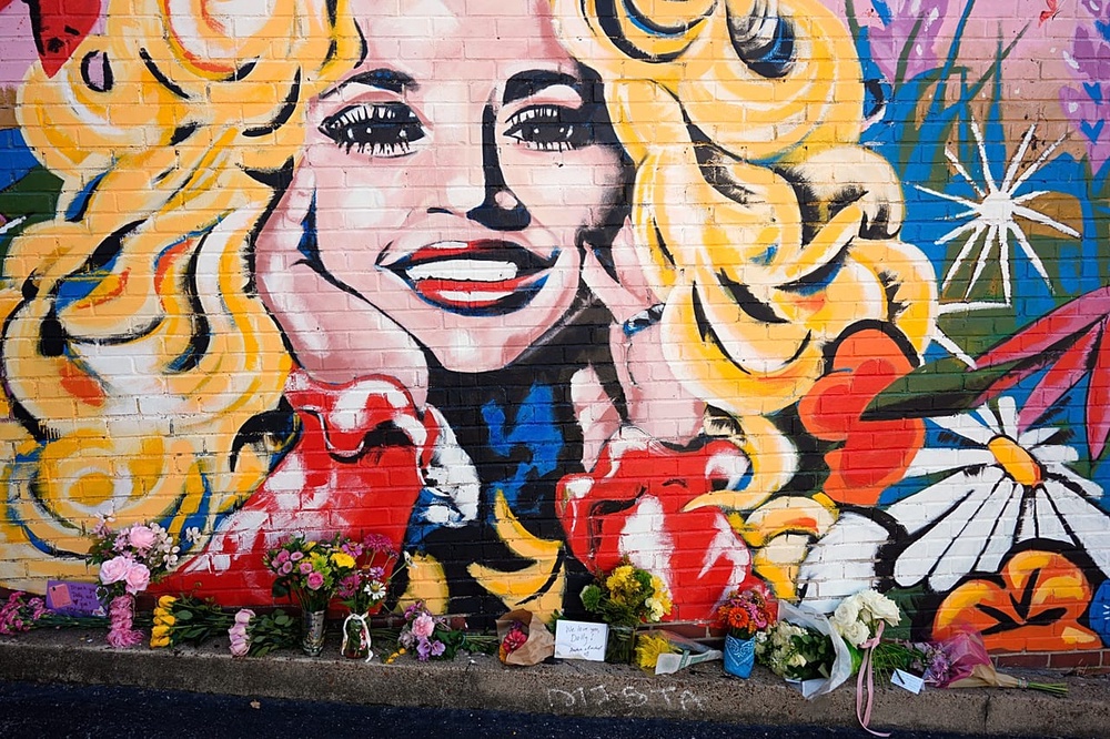 Flowers are placed near a mural of Dolly Parton on 25 August 2026, in Nashville, Tenn.