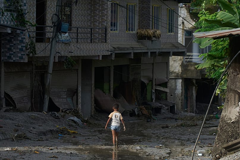 A child walks in mud in the aftermath of a flash floods in Devighat in the Nuwakot district in Nepal, Thursday, 27 Aug., 2026.
