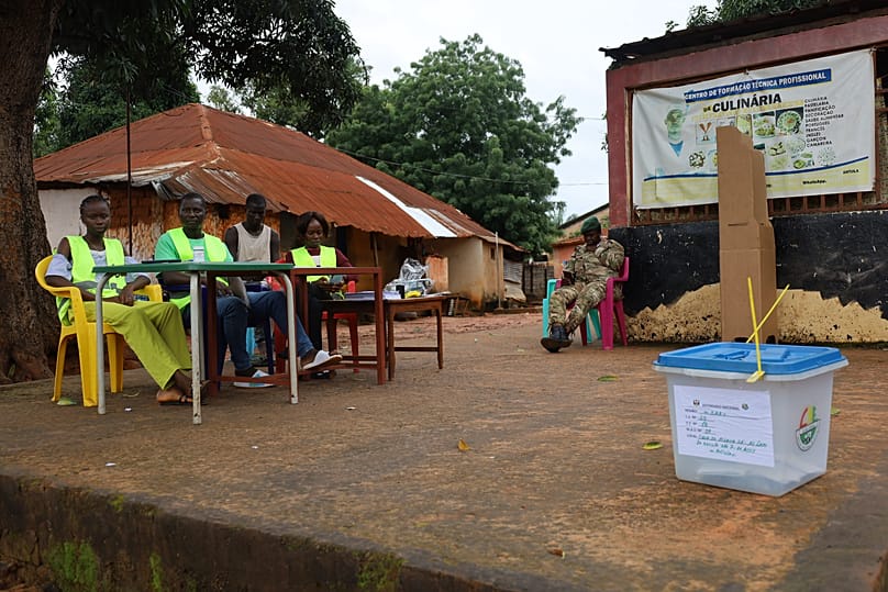 Election officials wait for voters to cast their ballots during a referendum on granting new presidential powers