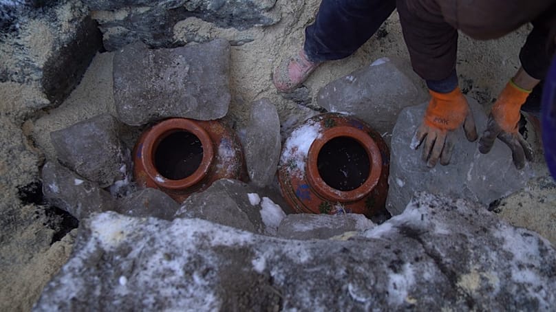 Two clay pots holding water from the river Indus separating 