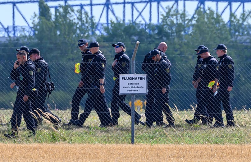 Police officers search the area away from north runway on the grounds of Leipzig/Halle Airport, 6 August, 2026