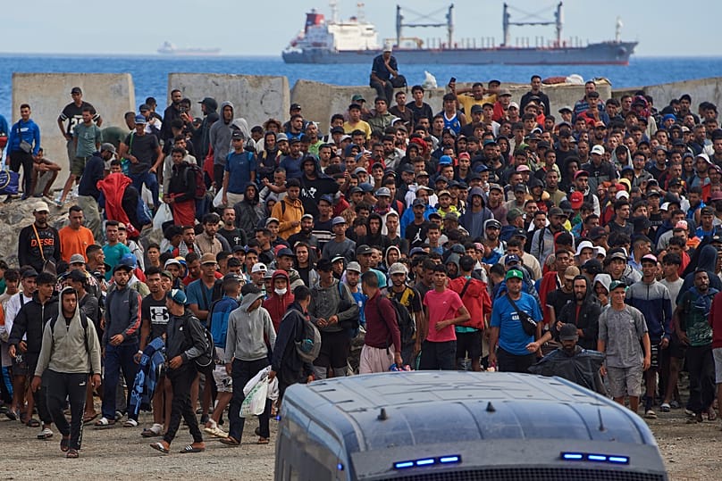 Migrants who crossed from Morocco into Spain return to a beach after being expelled from the area the previous day, as Spanish police escort them in the Spanish exclave.