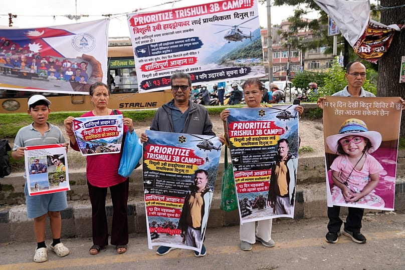 Relatives of recent flash flood victims hold banners urging authorities to step up efforts to find their missing loved ones during a demonstration in Kathmandu, 7 September, 2