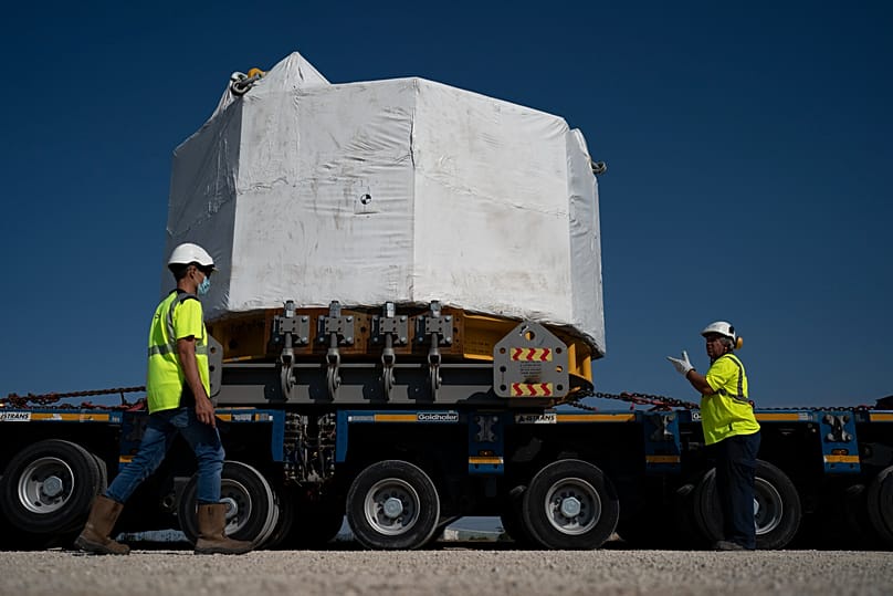 Workers secure a central solenoid magnet for the ITER project as it departs from Berre-l'Etang in southern France, Sept. 6, 2021.