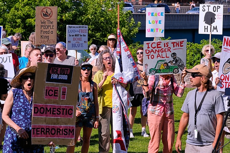 People hold signs during an anti-ICE protest in Biddeford, 17 July, 2026
