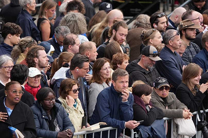 The public wait behind a barrier along the route of the procession for the funeral of Norway's King Harald V near Oslo Cathedral, 9 September, 2026