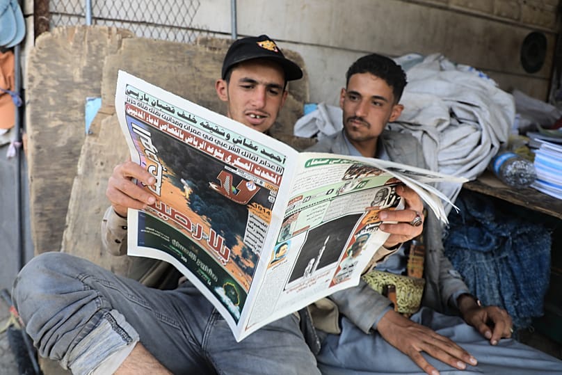 FILE: People read a newspaper to follow the war news at a shop in Sana'a, 8 September 2026
