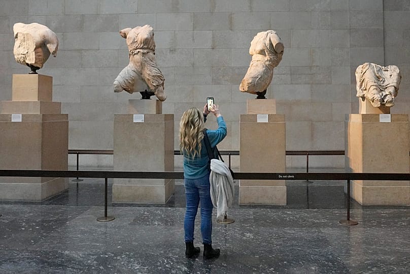 FILE: A visitor takes pictures of sculptures that are part of the Parthenon Marbles at the British Museum in London,