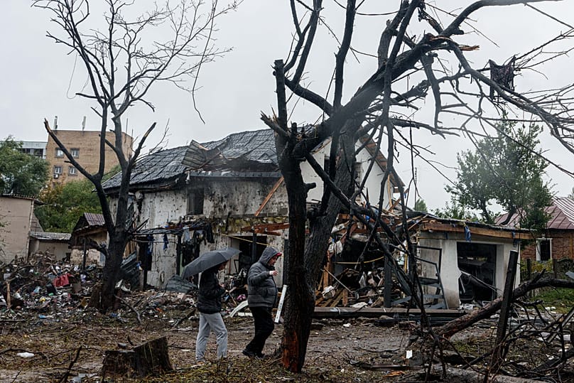 People walk in front of a house that was heavily damaged in a Russian strike on a residential neighbourhood in Kyiv, 24 September, 2026