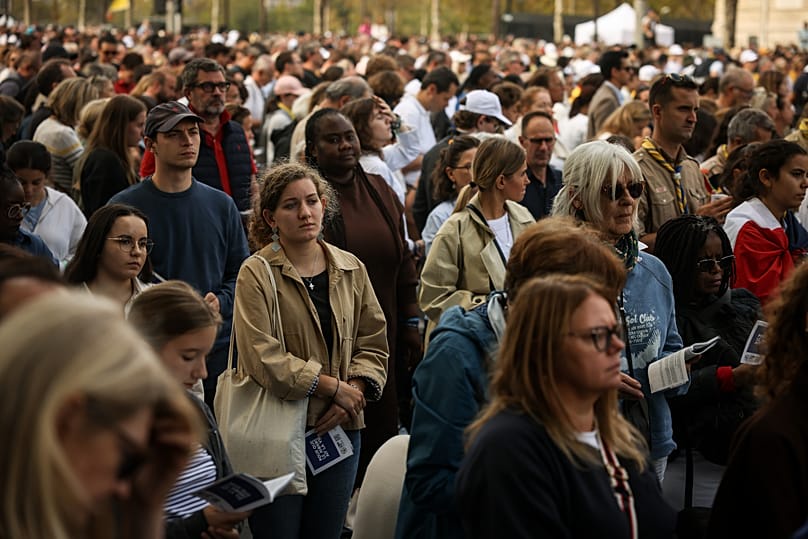 Faithful along on the Champs Elysees avenue follow a Mass celebrated by Pope Leo XIV at the Place de la Concorde in Paris, Saturday, Sept. 26, 2026. (AP Photo/Thomas Padilla)