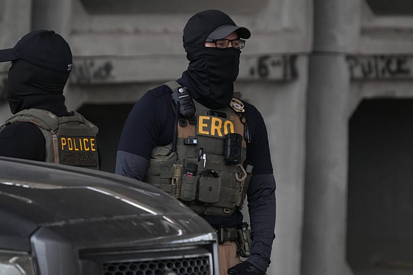 An Immigration and Customs Enforcement officer walks the scene where a man was shot in his vehicle by an ICE officer, Sunday, Sept. 20, 2026, in Austin, Texas