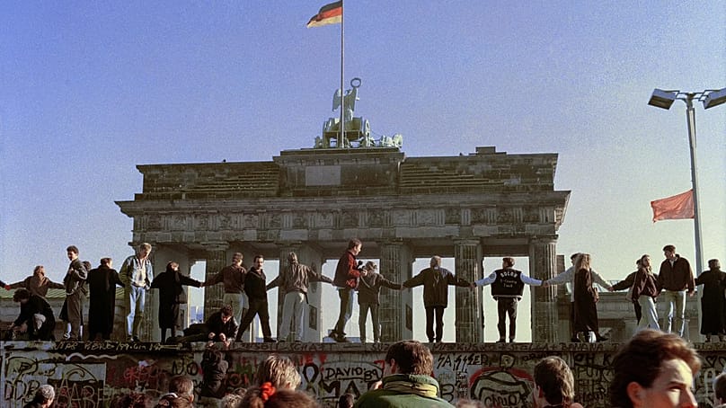 The day after the fall of the Wall, Berliners danced on top of it to celebrate the end of the inner-German border. (Archive: 10 November 1989)