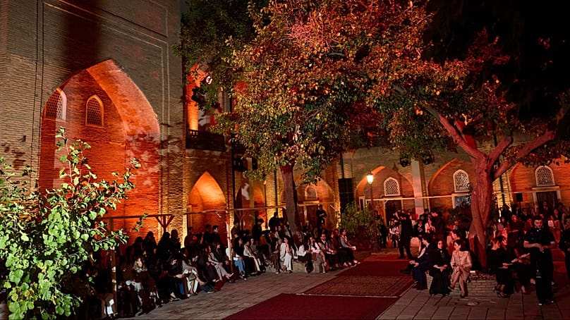 Guests gather around the carpet-lined courtyard of the Abulkasim Madrasah ahead of Brunello Cucinelli’s Fall-Winter 2026 fashion show in Tashkent, Uzbekistan