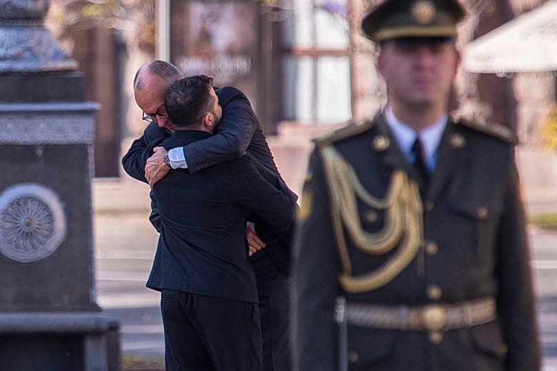 Ukrainian President Volodymyr Zelenskyy meets German Chancellor Friedrich Merz ahead of a memorial ceremony at a monument to fallen Ukrainian soldiers.