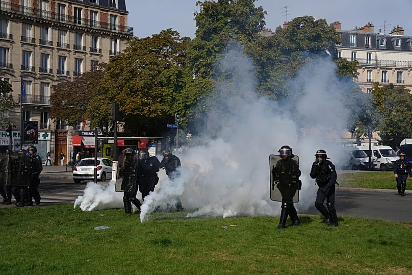 Police officers advance through tear gas facing pupils during a protest over a lack of resources, on Friday 2 October 2026 in Paris.
