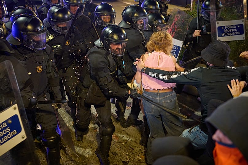 Riot police use their batons to disperse protesters after a demonstration over Spain's housing crisis, in Barcelona, on 5 October 2026. 