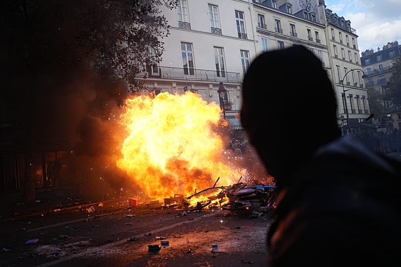 Protesters stand in front of burning bicycles during a demonstration against rising living costs, joining students' grievances, in Paris, Saturday, Oct. 17, 2026.