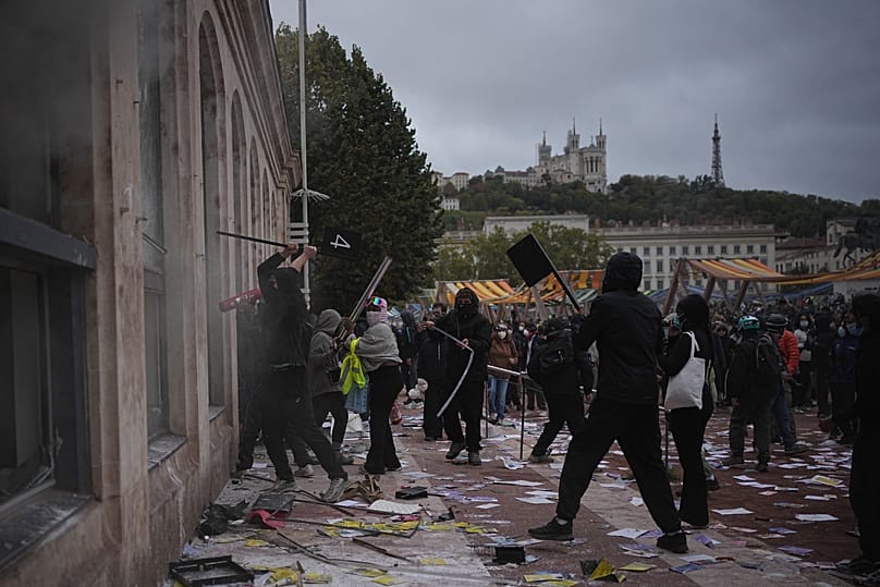 Protesters attack a tourism office during a demonstration against rising living costs, joining students' grievances, in Lyon, France, Saturday, Oct. 17, 2026.