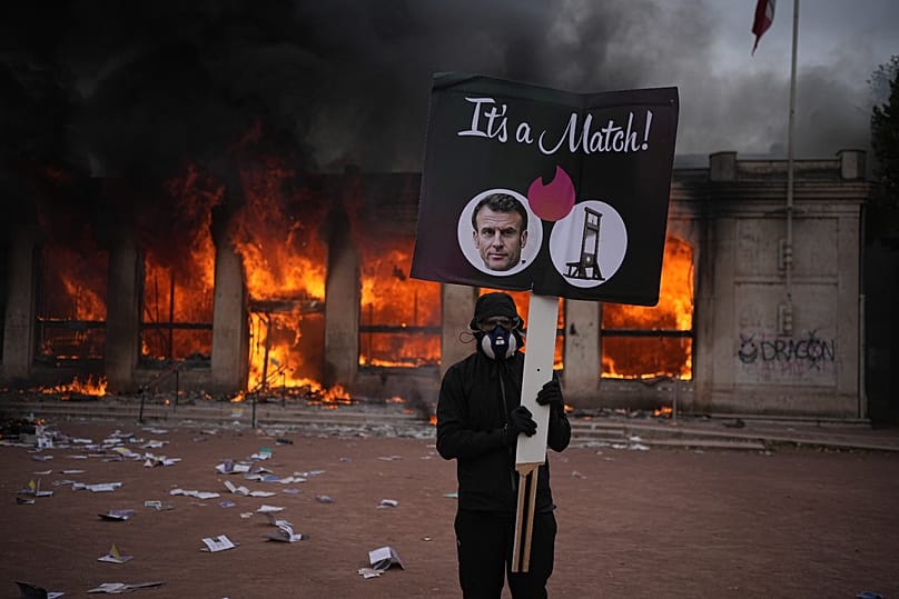 A burning tourism office during a demonstration against rising living costs and in solidarity with students’ grievances in Lyon, France, Saturday, Oct. 17.