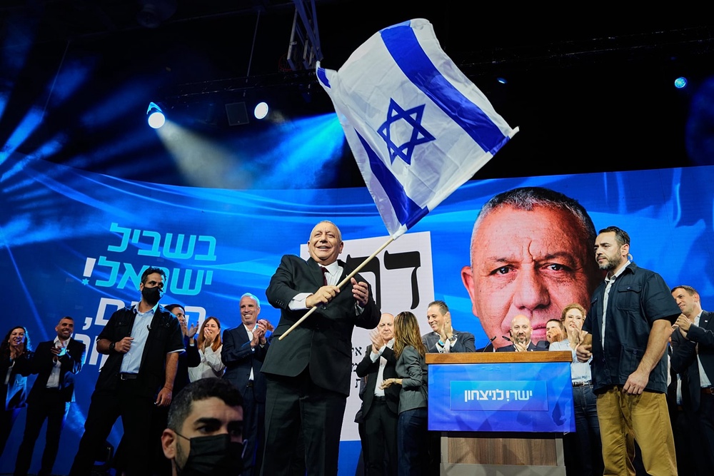 Gadi Eisenkot waves an Israeli flag onstage following the release of the first exit poll results in Israel's general election in Tel Aviv, Israel, Wednesday, Oct. 28, 2026. 