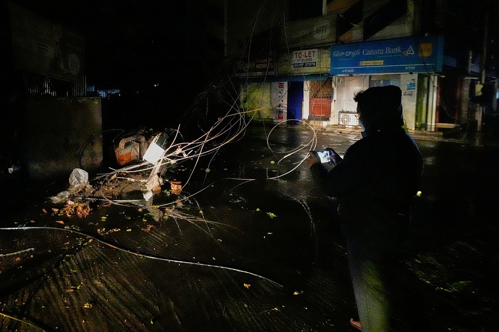 A man films an electrical transformer toppled by heavy rain and strong winds as Cyclone Arnab approaches the Andhra Pradesh coast in Kakinada, India, Tuesday, Oct. 27, 2026.